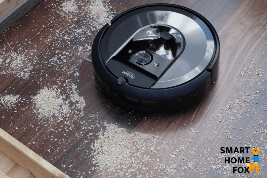 iRobot Roomba i7 Plus vacuums oatmeal on laminate flooring.